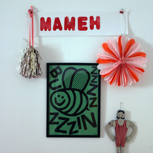 Decorative wall hanging with colorful items including a nameplate, cartoon characters, and a buzzin bee-themed picture.