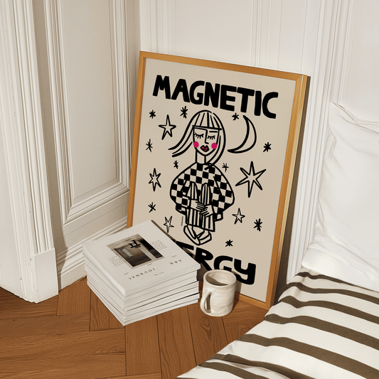 Framed artwork with a stylized illustration and text on a ledge next to books and a mug.