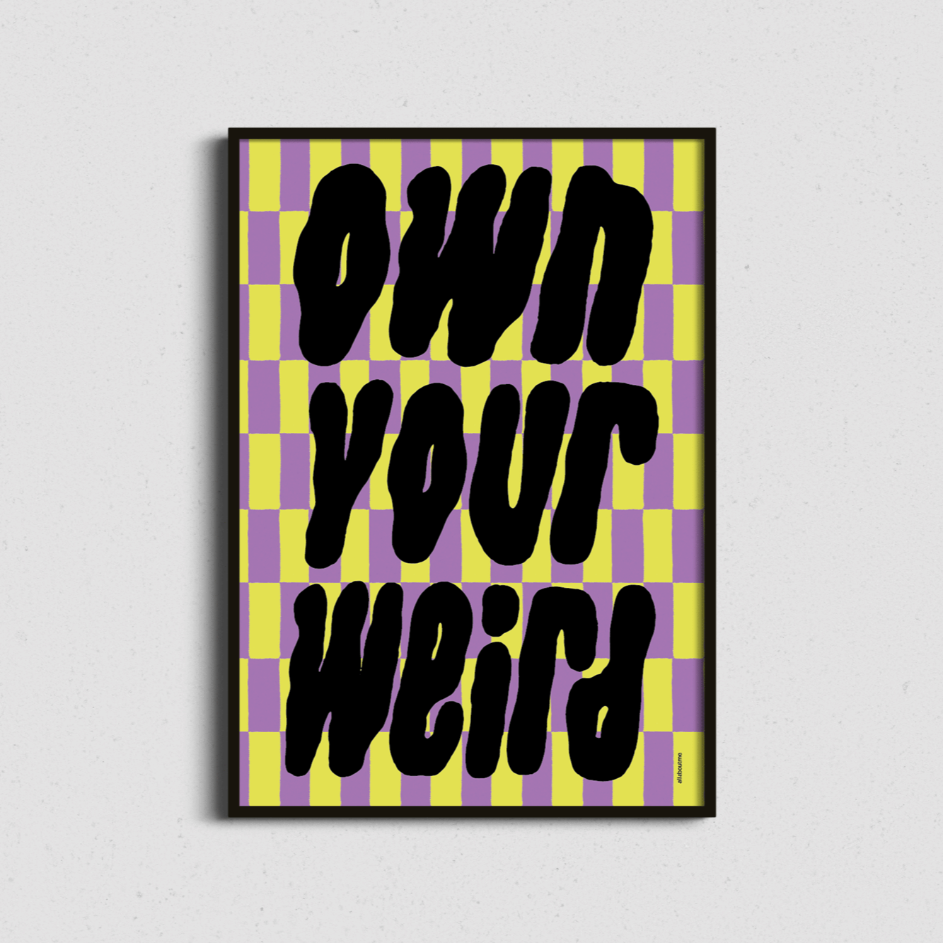 Framed artwork with 'Own Your Weird' text on a checkered background