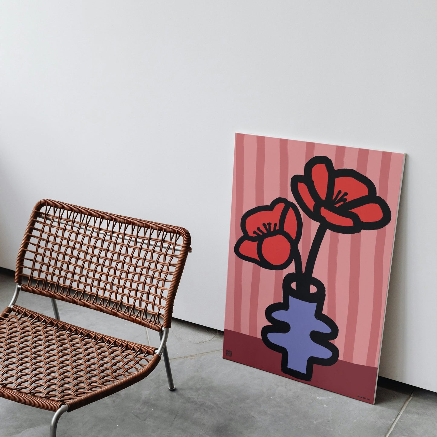 Artistic depiction of red poppy birth flowers in a vase on a pink striped background next to a wicker chair.
