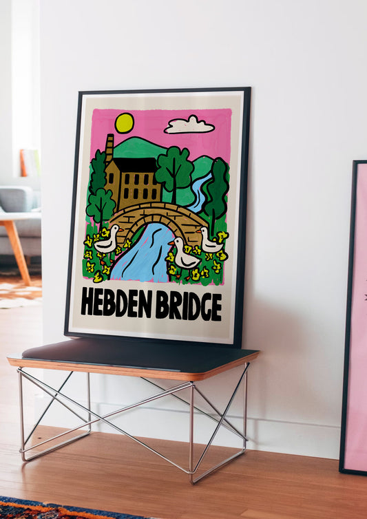 Framed artwork with 'Hebden Bridge' design on a table against a white wall.