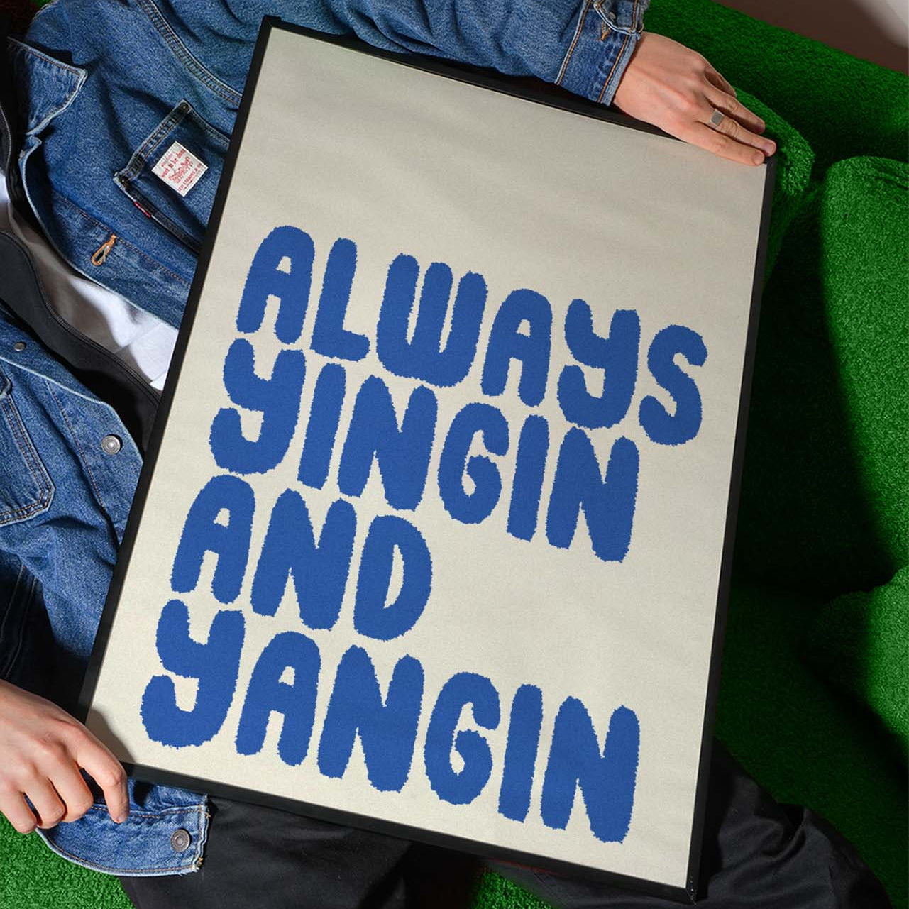 Person holding a sign with 'Always Yingin and Yangin' text on a green surface