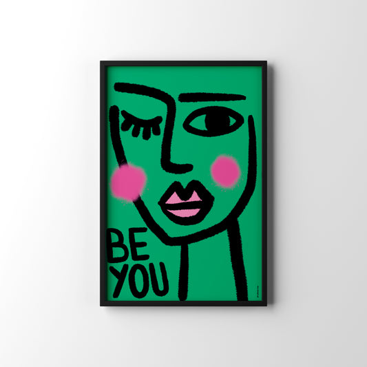 Framed artwork with a stylized face and 'BE YOU' text on a green background
