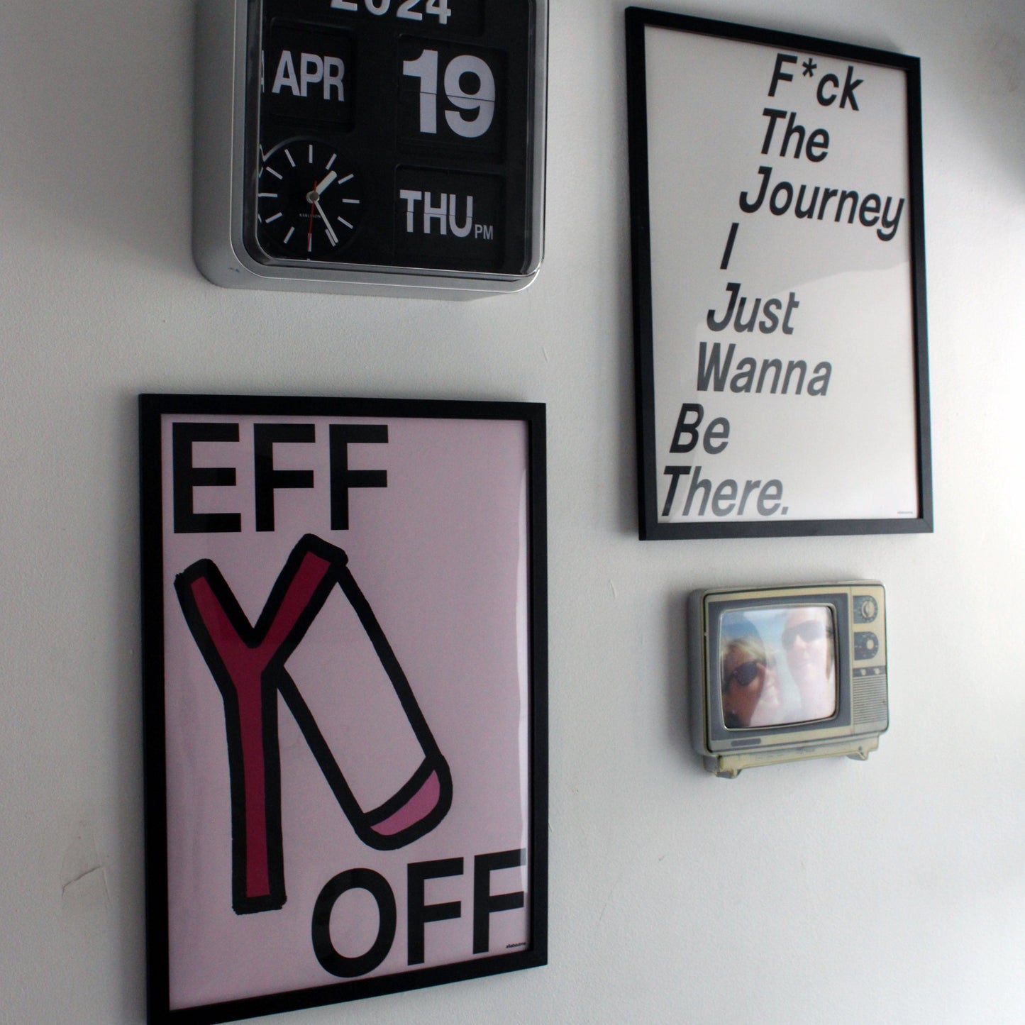 motivational artworks on a wall, including a calendar, a motivational quote, a graphic with text, and a small photo frame.
