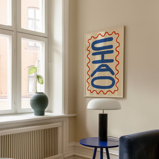 Add a fun, playful touch with the Ciao Wiggle Sicily Print. Hand-drawn Italian-inspired art, perfect for brightening up your home decor.
Modern interior with a window, plant, lamp, and abstract art on the wall.