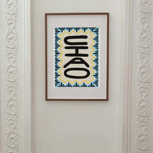 Framed artwork with a stylized text design on a wall.
