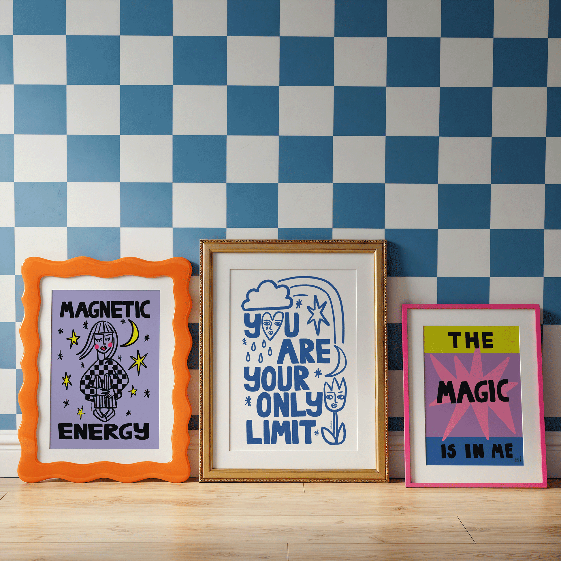 Three framed posters with motivational quotes on a checkered wall.