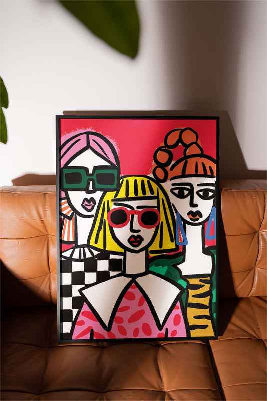 Framed artwork of stylised portraits  Illustration of confident women supporting each other and celebrating friendship.on a brown leather surface