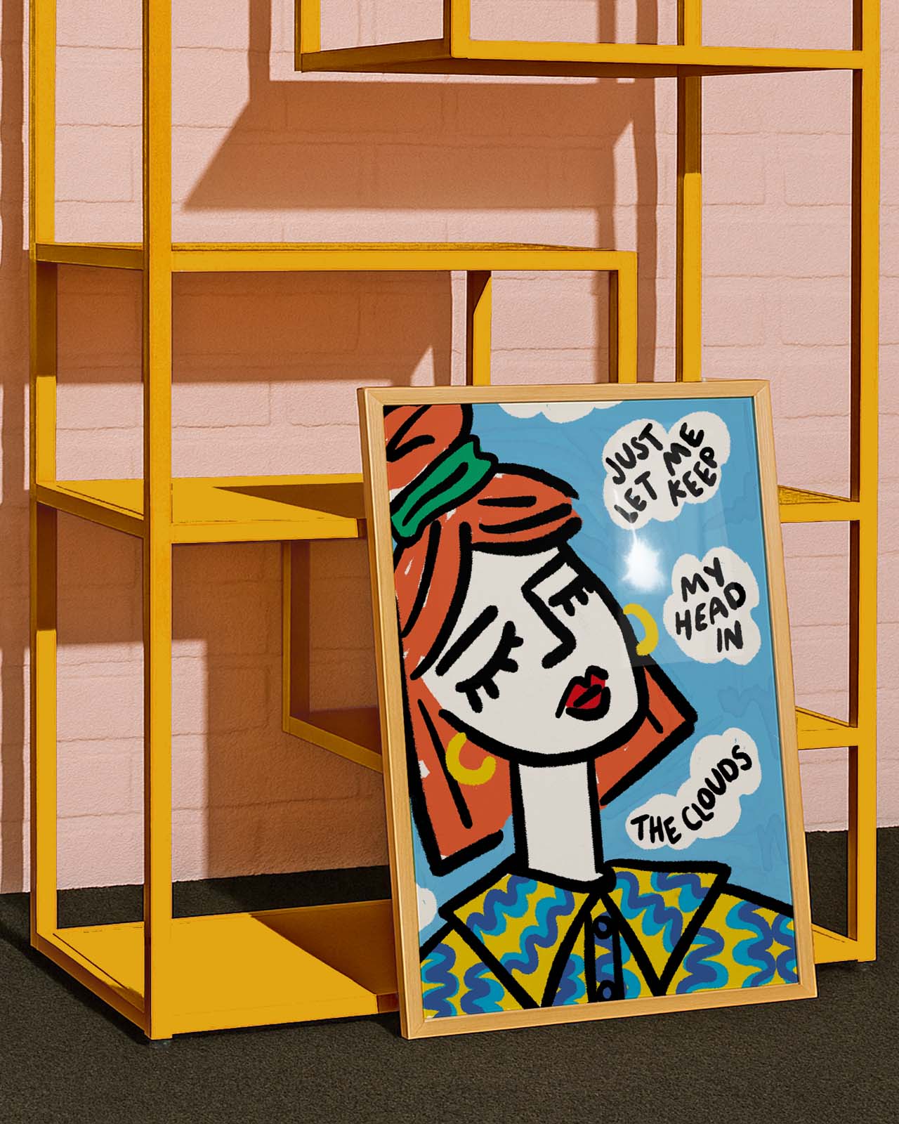 Colorful abstract art print on a stand against a yellow shelf and pink wall.