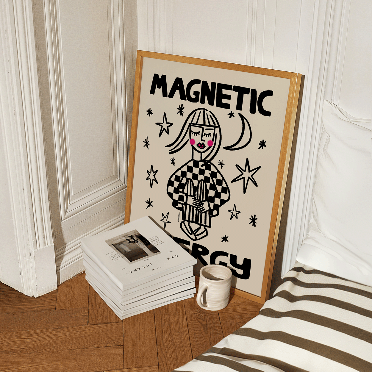 Framed artwork with a stylized illustration and text on a ledge next to books and a mug.