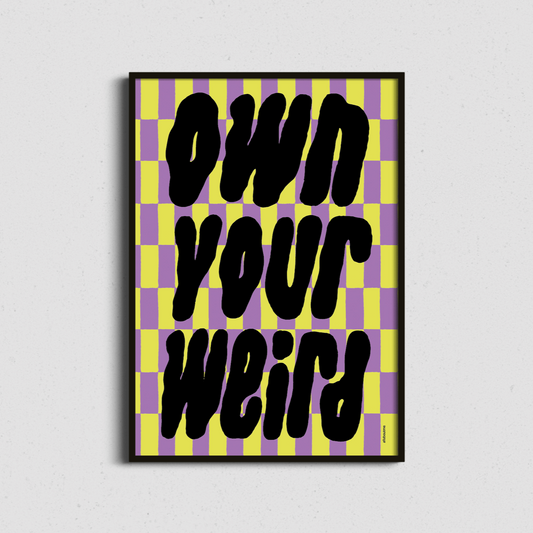 Framed artwork with 'Own Your Weird' text on a checkered background