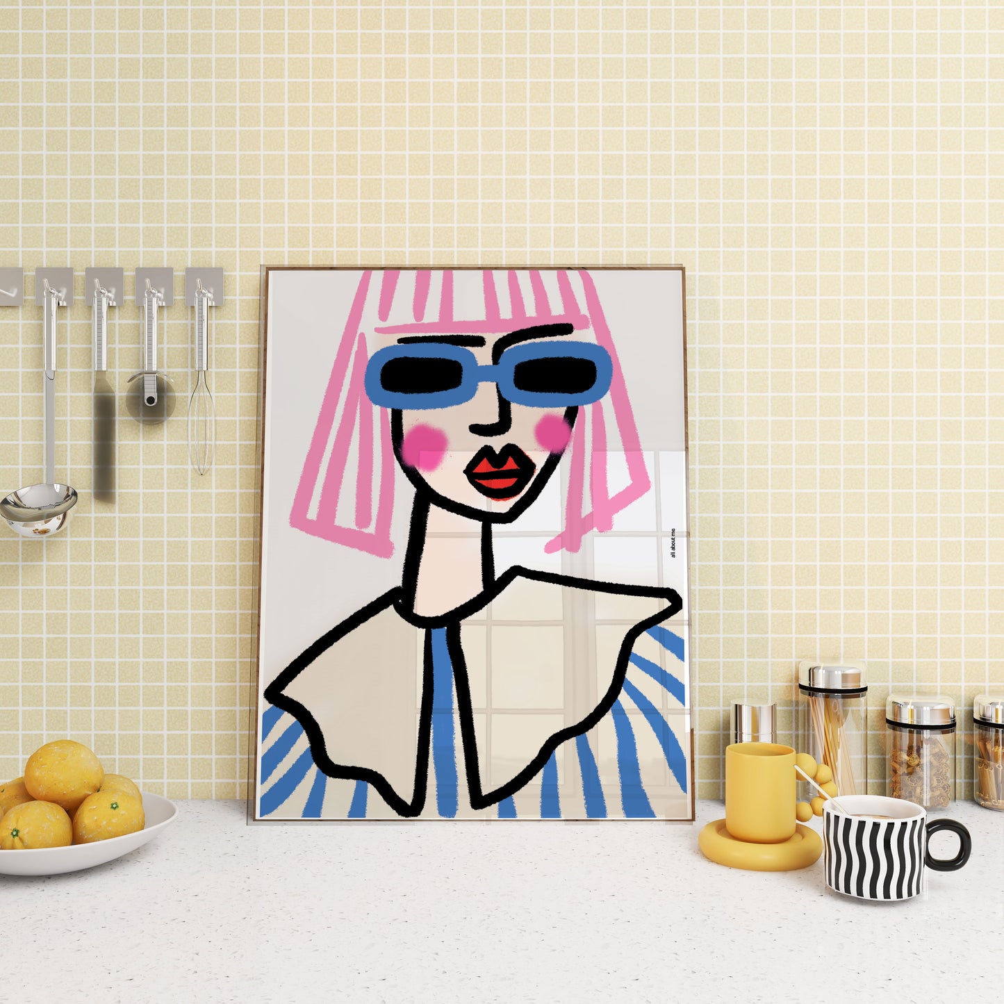Abstract art print of a stylized face with sunglasses on a kitchen wall.