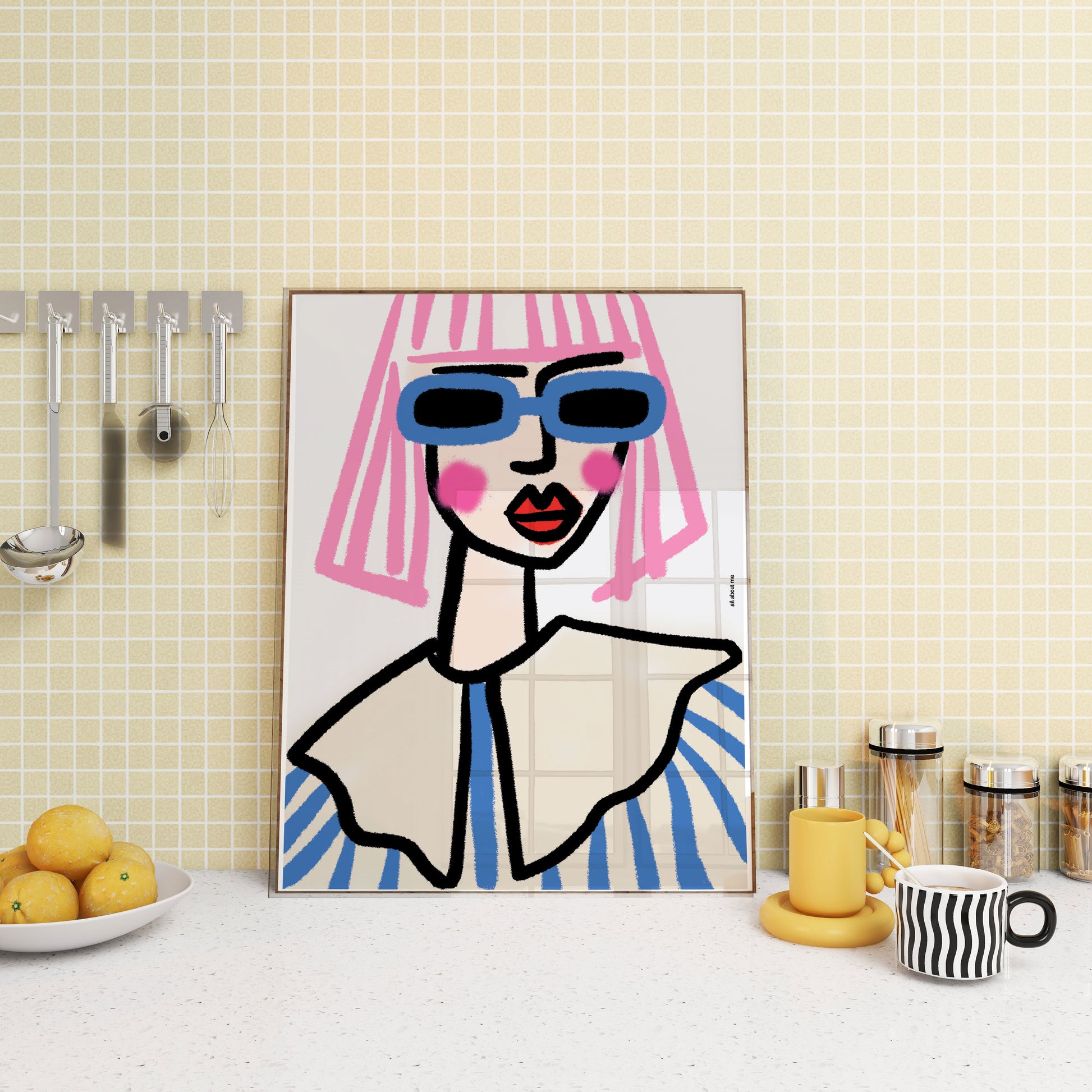 Abstract art print of a stylized face with sunglasses on a kitchen wall.