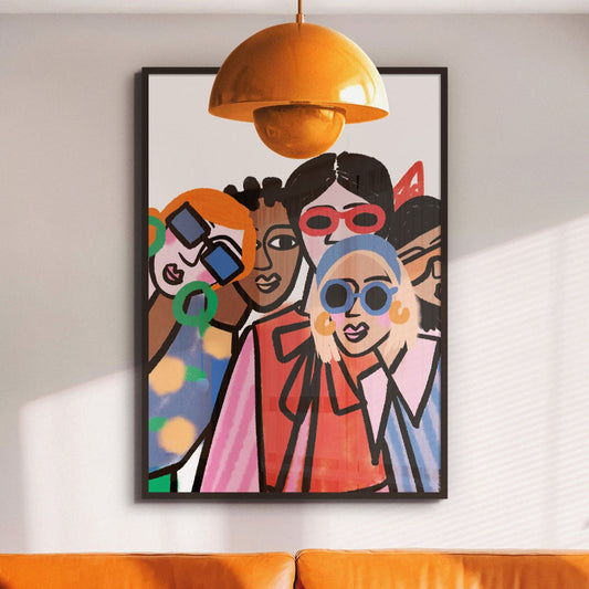 Framed ‘Street Style Best Friends’ fashion art print depicting two stylish friends in casual streetwear. Colorful abstract painting on a wall above an orange sofa with a yellow pendant light.