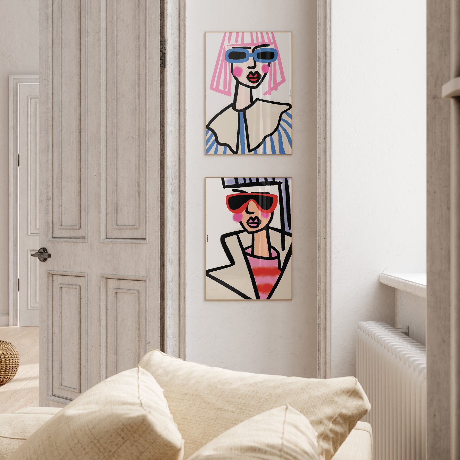 Two abstract artworks of stylized figures wearing sunglasses on a white wall.