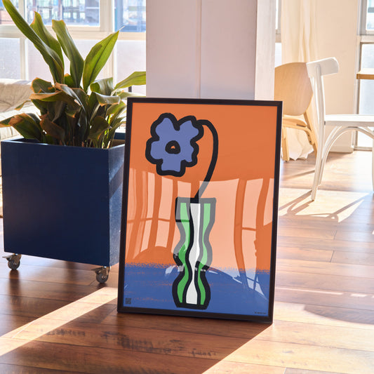 Charming Violet flower print for February birthdays. Includes a heartfelt audio poem celebrating this delicate birth flower’s symbolism.
Framed abstract artwork with a blue flower on an orange background in a living room.