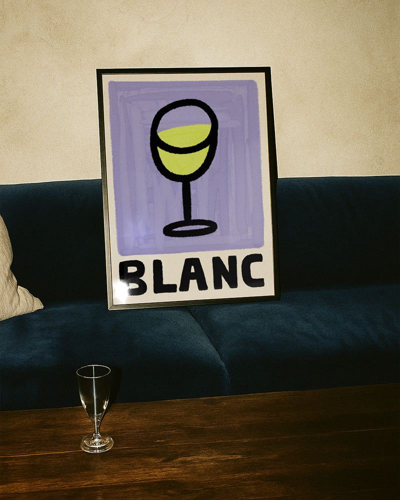 Framed artwork with a wine glass and 'BLANC' text on a couch.
